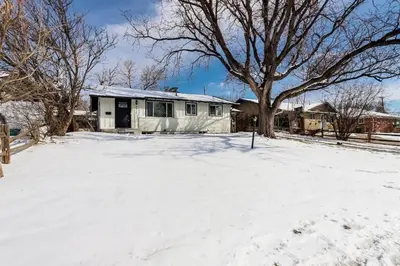 a house in a snow covered yard with a tree at The Western Retreat With Hot Tub and Spacious Yard in Westminster