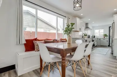 a kitchen and dining room with a wooden table and white chairs at The Western Retreat With Hot Tub and Spacious Yard in Westminster