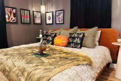 a bedroom with a bed with a blanket and pillows at NEW The Emerald Haus Near Regis and Denver in Denver
