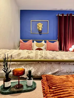 a bedroom with a bed with a blue wall at NEW The Emerald Haus Near Regis and Denver in Denver