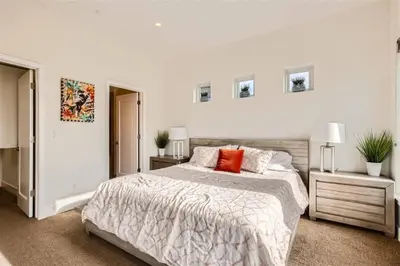 a white bedroom with a large bed and two night stands at With Pool Table Near to RiNo and City Park in Denver