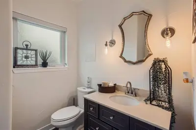 a bathroom with a sink and a toilet and a mirror at With Pool Table Near to RiNo and City Park in Denver
