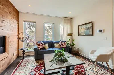 a living room with a blue couch and a fireplace at With Pool Table Near to RiNo and City Park in Denver