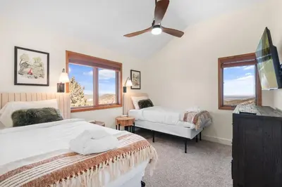 a bedroom with two beds and a ceiling fan at Mountain Retreat Sleeps 10 with Pool Table and Arcade in Littleton