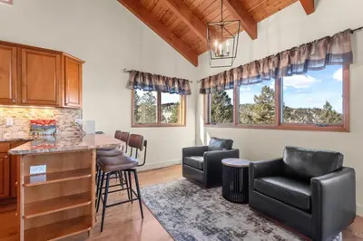 a kitchen and living room with a table and chairs at Mountain Retreat Sleeps 10 with Pool Table and Arcade in Littleton