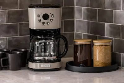 a coffee maker sitting on a counter next to two jars at Spacious and Stylish Home with HotTub 12min to Downtown in Westminster