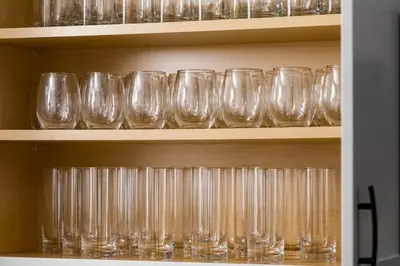 a row of empty glasses sitting on a shelf at Spacious and Stylish Home with HotTub 12min to Downtown in Westminster