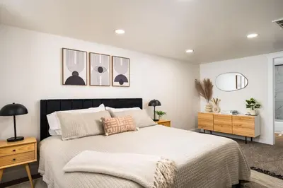 a bedroom with a large bed with white walls at Spacious and Stylish Home with HotTub 12min to Downtown in Westminster