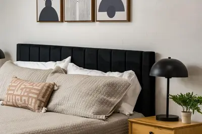 a bed with a black headboard and pillows on it at Spacious and Stylish Home with HotTub 12min to Downtown in Westminster