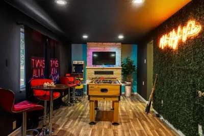 a room with a bar with red chairs and a tv at Denver Hype House - 8 min to DT in Denver