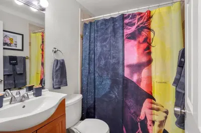 a bathroom with a shower curtain and a sink at Denver Hype House - 8 min to DT in Denver