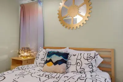 a bedroom with a bed and a clock on the wall at Denver Hype House - 8 min to DT in Denver
