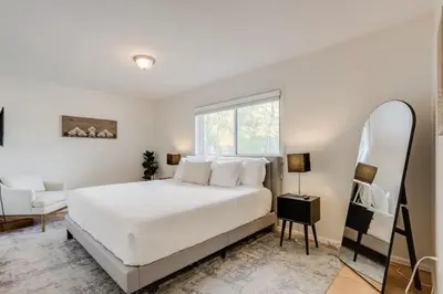 a bedroom with a white bed and a mirror at Spacious and Stylish Home With Fast Wifi and Near to Downtown in Denver