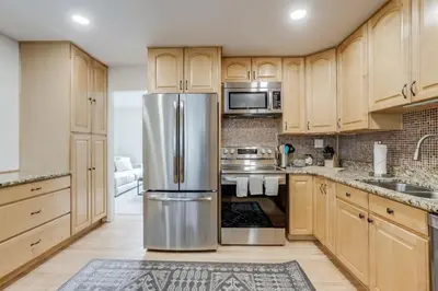 a kitchen with wooden cabinets and a stainless steel refrigerator at Spacious and Stylish Home With Fast Wifi and Near to Downtown in Denver