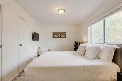 a white bedroom with a large bed with white pillows at Spacious and Stylish Home With Fast Wifi and Near to Downtown in Denver