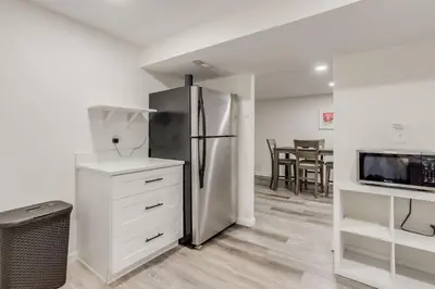 a kitchen with a refrigerator and a table with chairs at Spacious and Stylish Home With Fast Wifi and Near to Downtown in Denver