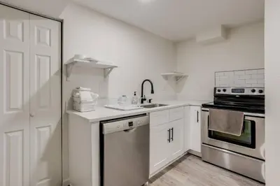 a white kitchen with a sink and a stove at Spacious and Stylish Home With Fast Wifi and Near to Downtown in Denver