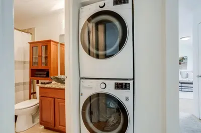 two washing machines are stacked in a bathroom at Spacious and Stylish Home With Fast Wifi and Near to Downtown in Denver
