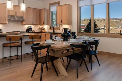 a kitchen with a wooden table and chairs in a kitchen at Downtown Fraser with Hot Tub in Fraser