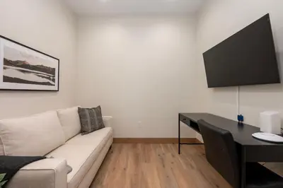 a living room with a couch and a desk with a television at Downtown Fraser with Hot Tub in Fraser