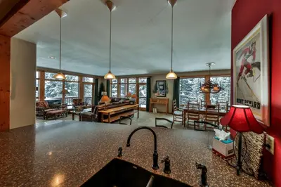 a kitchen with a sink and a living room at Rocky Mountain Retreat Steps to Slopes with Hot Tub and Spectacular Views in Winter Park
