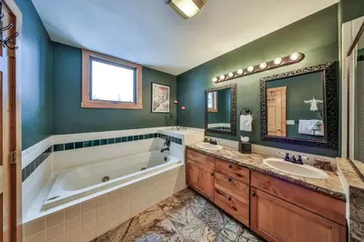 a bathroom with a tub and a sink and a tub and a mirror at Rocky Mountain Retreat Steps to Slopes with Hot Tub and Spectacular Views in Winter Park