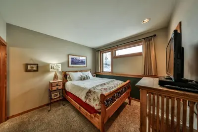 a bedroom with a bed and a flat screen tv at Rocky Mountain Retreat Steps to Slopes with Hot Tub and Spectacular Views in Winter Park