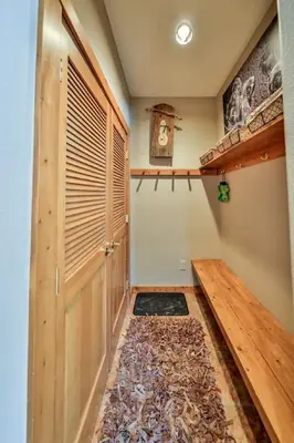 a hallway with a wooden door and a rug at Rocky Mountain Retreat Steps to Slopes with Hot Tub and Spectacular Views in Winter Park