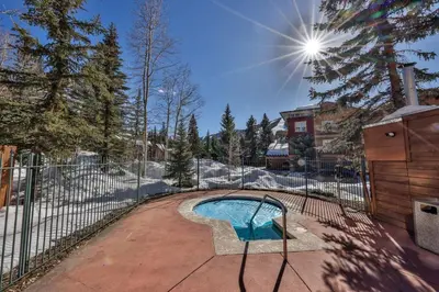 a fence around a swimming pool in a yard at Rocky Mountain Retreat Steps to Slopes with Hot Tub and Spectacular Views in Winter Park