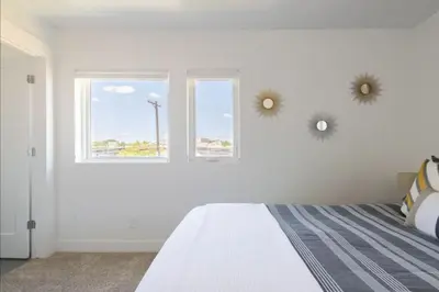 a white bedroom with a bed and two windows at New Build and Pet Friendly Near to Highlands and RiNo in Denver