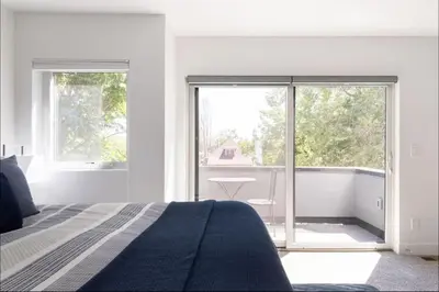 a white bedroom with a bed and a large window at New Build and Pet Friendly Near to Highlands and RiNo in Denver