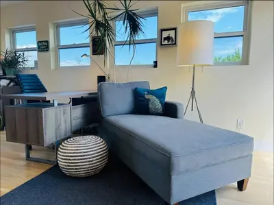 a living room with a blue couch and a table at New Build and Pet Friendly Near to Highlands and RiNo in Denver
