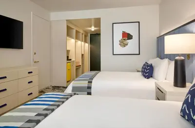 a bedroom with two beds and a flat screen tv at Limelight Boulder in Boulder