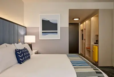 a bedroom with a large white bed with a blue pillow at Limelight Boulder in Boulder