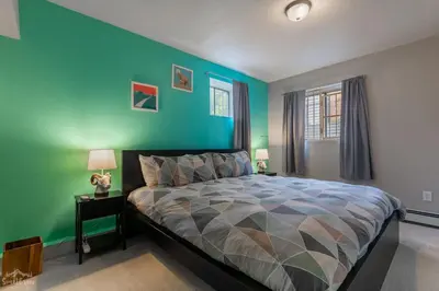 a bedroom with a bed with a green wall at Charming 2 Bed Start Your Denver Adventure in Denver