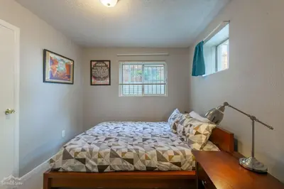 a bedroom with a bed and a desk and two windows at Charming 2 Bed Start Your Denver Adventure in Denver