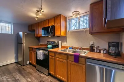 a kitchen with wooden cabinets and a stainless steel refrigerator at Charming 2 Bed Start Your Denver Adventure in Denver