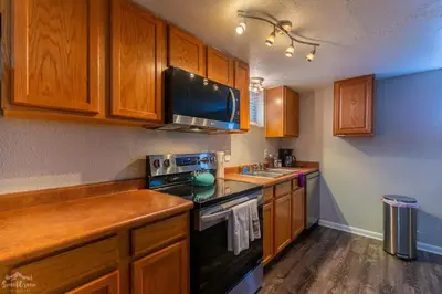 a kitchen with wooden cabinets and a stove top oven at Charming 2 Bed Start Your Denver Adventure in Denver