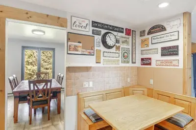 a dining room with a table and a clock on the wall at The Four Pines Near to Red Rocks And Morrison in Morrison