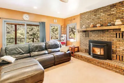 a living room with a leather couch and a fireplace at The Four Pines Near to Red Rocks And Morrison in Morrison