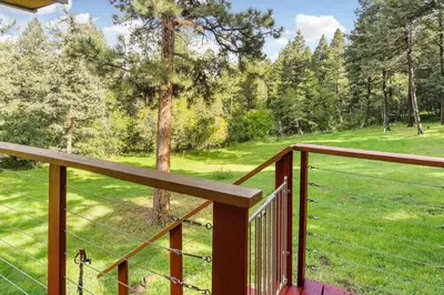 a deck with a view of a field and trees at The Four Pines Near to Red Rocks And Morrison in Morrison