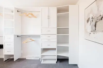 a white walk in closet with white cabinets at Luxe Home with Hot Tub Movie Room and Firepit Near Denver in Arvada