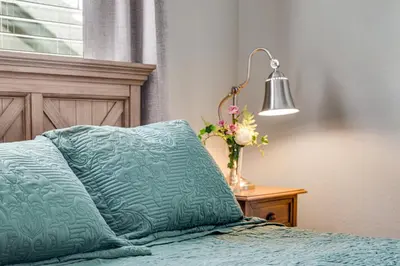 a bed with a pillow and a lamp on a table at 5 bed 4 bath and Pet friendly in Erie