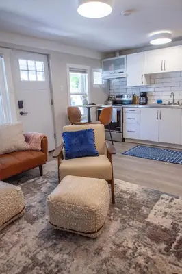 a living room with a couch and chairs and a kitchen at Zuni St Motor Inn- Bike, Dine, Explore Denver in Denver