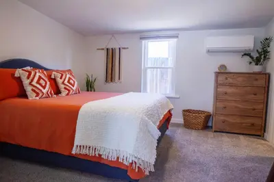a bedroom with a bed and a dresser and a window at Zuni St Motor Inn- Bike, Dine, Explore Denver in Denver