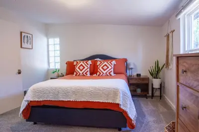 a bedroom with a bed with orange pillows on it at Zuni St Motor Inn- Bike, Dine, Explore Denver in Denver
