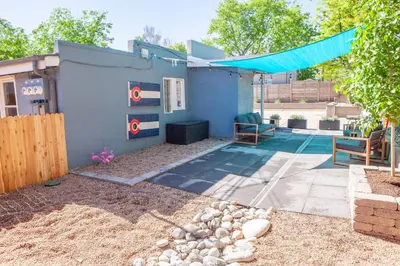 a backyard with a pool and a blue house at Zuni St Motor Inn- Bike, Dine, Explore Denver in Denver