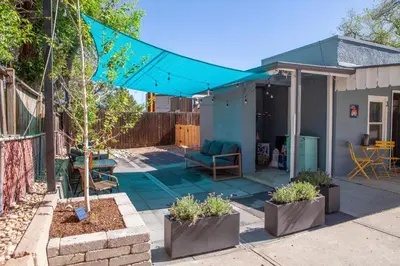 a patio with a blue umbrella in a yard at Zuni St Motor Inn- Bike, Dine, Explore Denver in Denver