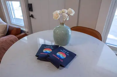 a white table with a vase with flowers and two passports at Zuni St Motor Inn- Bike, Dine, Explore Denver in Denver