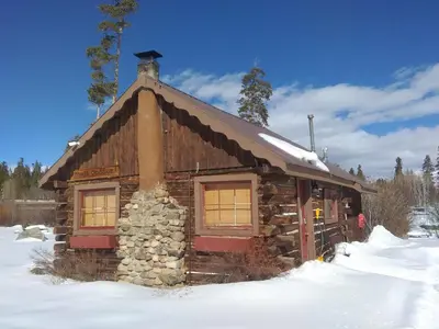a log cabin with snow on the ground at Colorado Cabin Adventure in Grand Lake